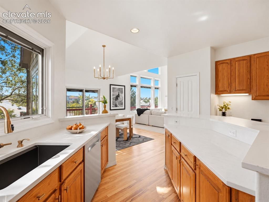 Image 7 of 48: Kitchen featuring wood cabinetry, white countertops, a deep-basin sink with