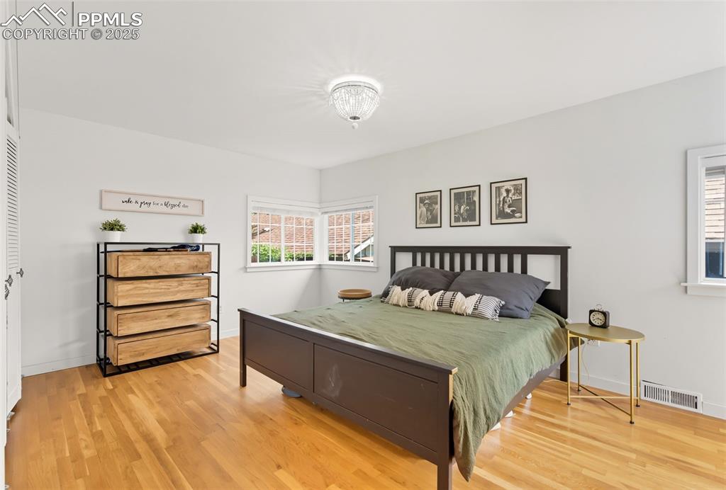 Image 23 of 49: Primary bedroom has oak floors