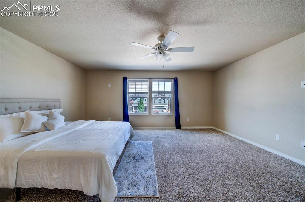 Image 21 of 46: Bedroom featuring carpet, a textured ceiling, and a ceiling fan