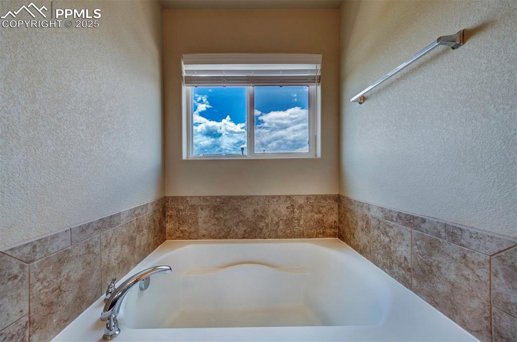 Image 26 of 46: Bathroom with a garden tub and a textured wall