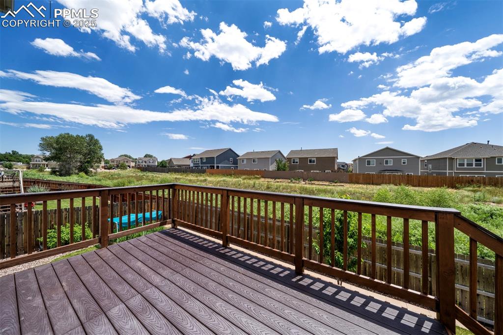 Image 37 of 46: Wooden terrace featuring a residential view and a fenced backyard