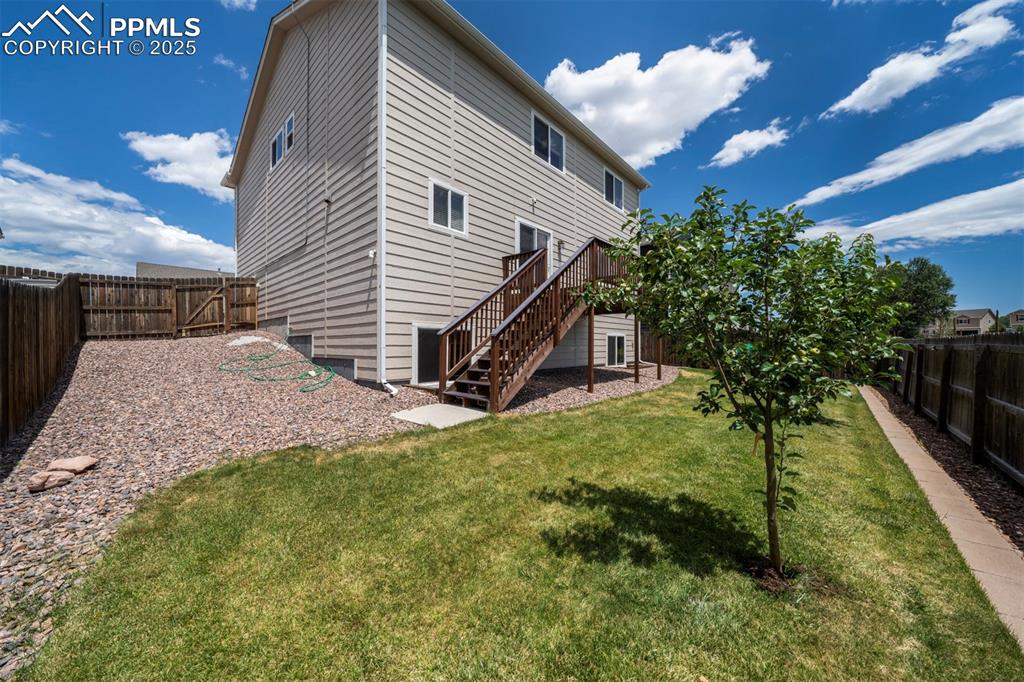 Image 38 of 46: Rear view of property with stairway, a fenced backyard, and a wooden deck