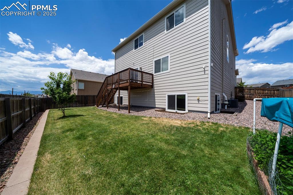 Image 39 of 46: Rear view of property with a fenced backyard, a wooden deck, and stairs