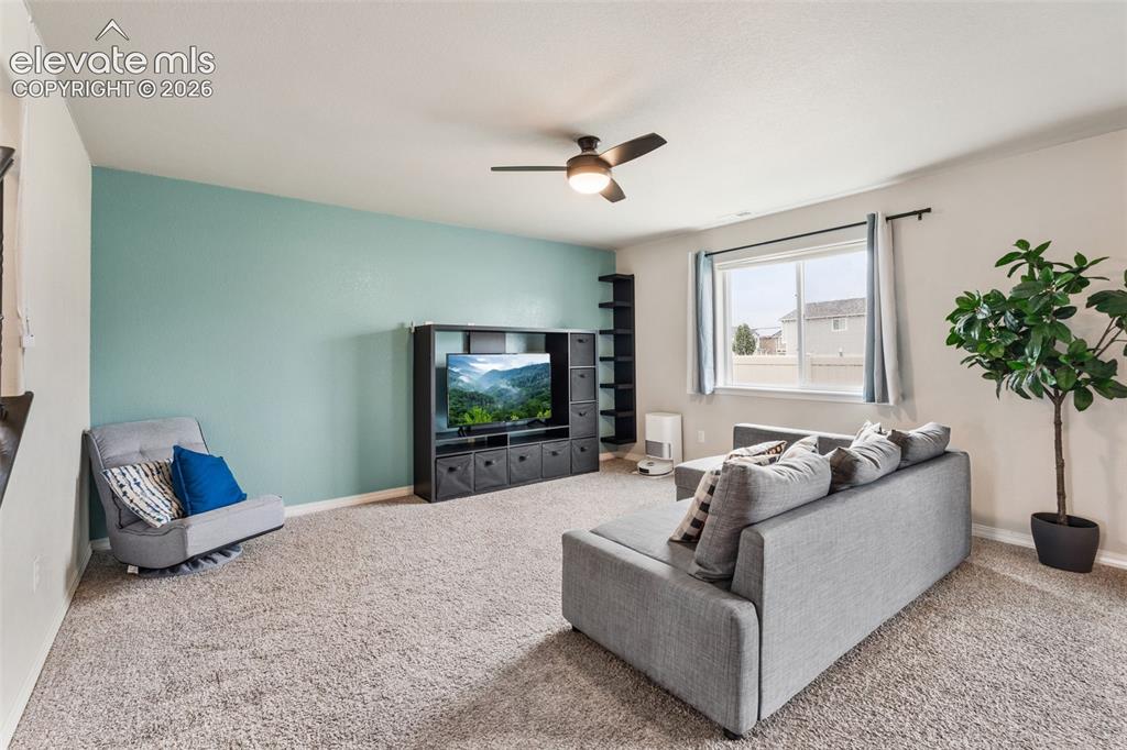 Image 10 of 42: Carpeted living space featuring a window, built-in shelving, and a ceiling
