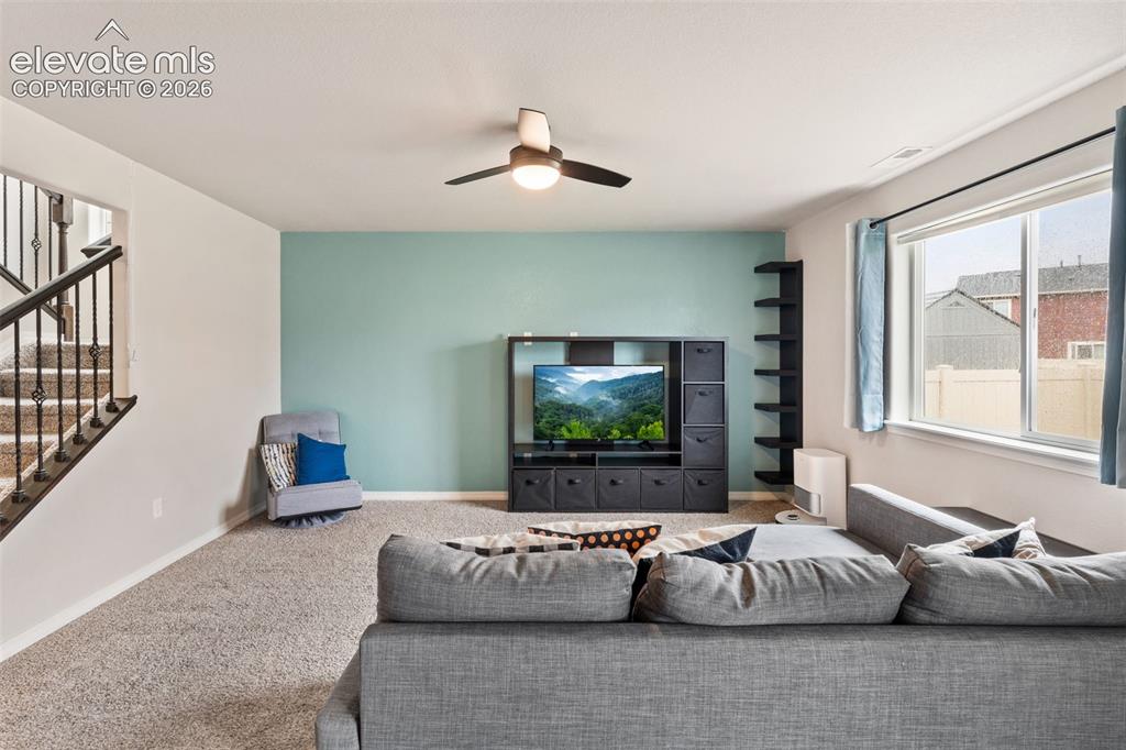 Image 11 of 42: Carpeted room featuring a ceiling fan, a window with blinds, and a built-in