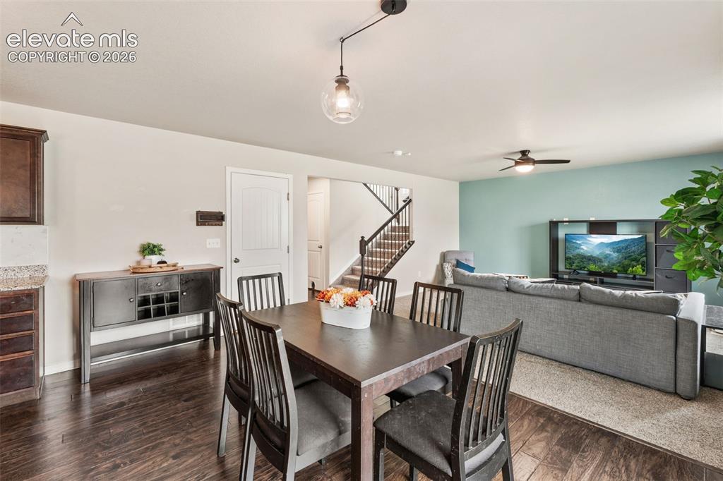 Image 15 of 42: Wood-finish flooring, staircase with dark wood railings, light neutral wall