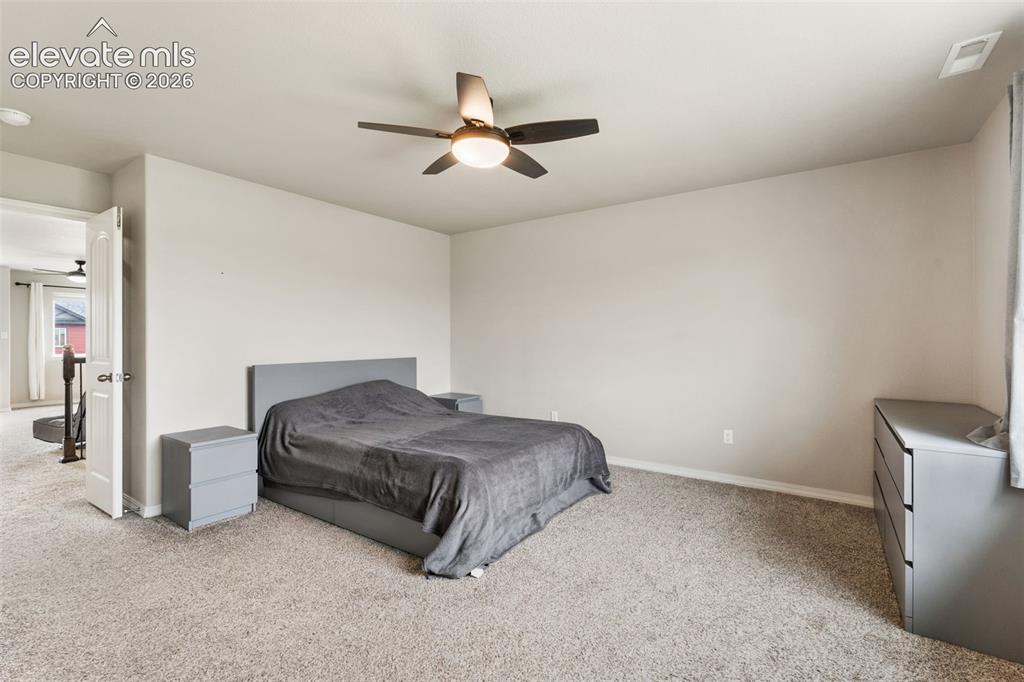Image 24 of 42: Carpeted bedroom featuring a ceiling fan with integrated lighting