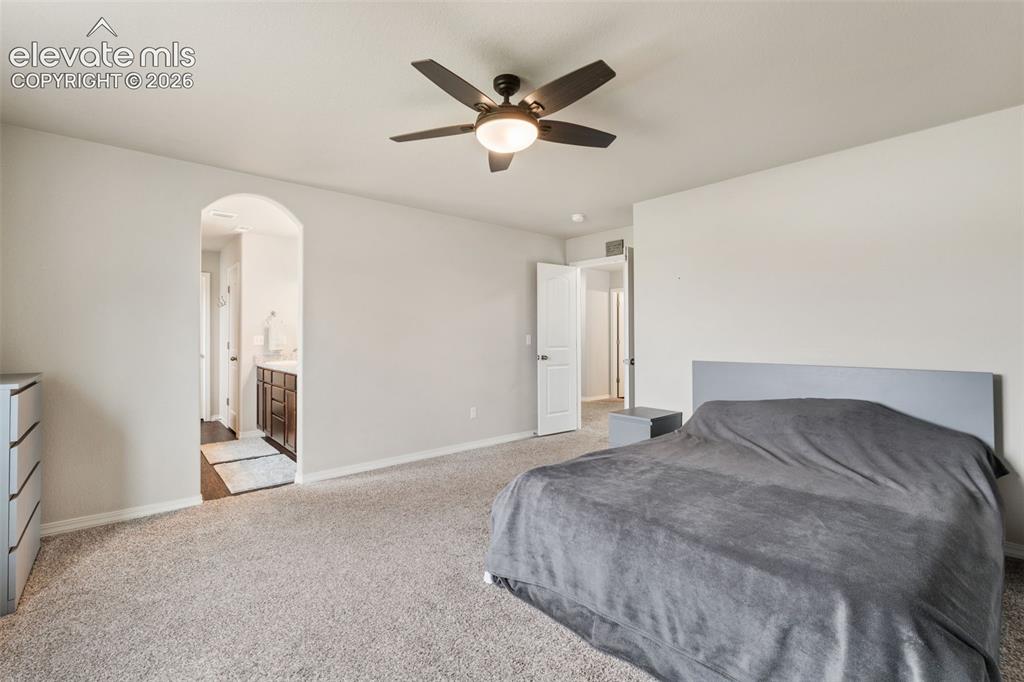 Image 25 of 42: Carpeted flooring, vaulted ceiling, and an arched doorway