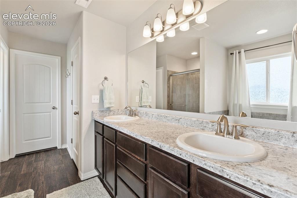 Image 26 of 42: Dual vanity with undermount sinks and extensive countertop space, large wal