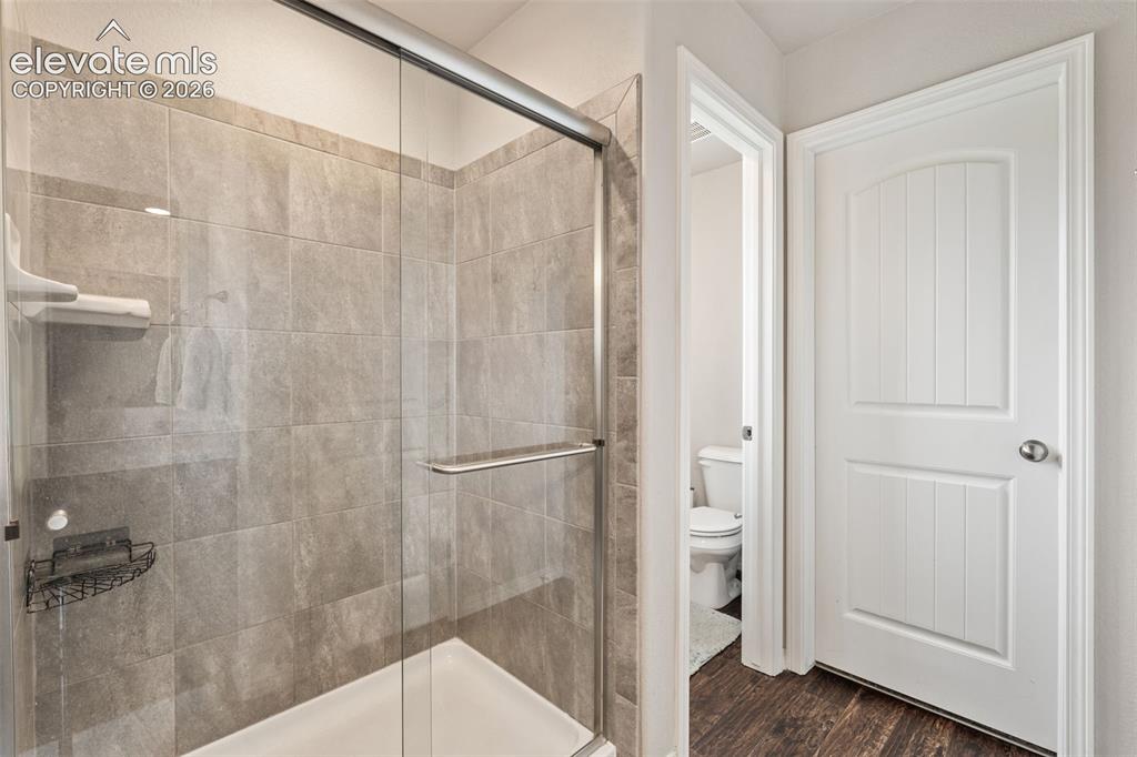 Image 28 of 42: Shower with clear glass enclosure and light-toned tile surround