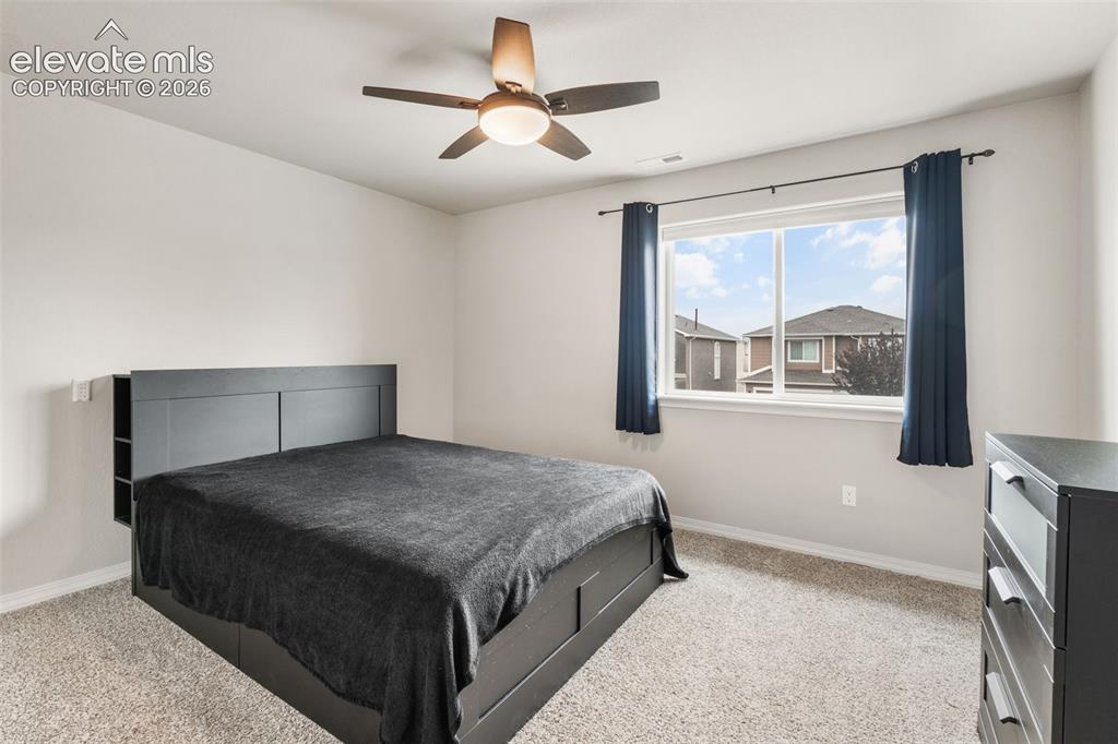 Image 32 of 42: Wall-to-wall carpeting, window with a white frame, and a ceiling fan with i