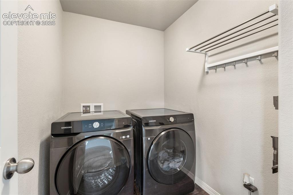 Image 34 of 42: Compact utility space featuring a wall-mounted drying rack with hanging hoo