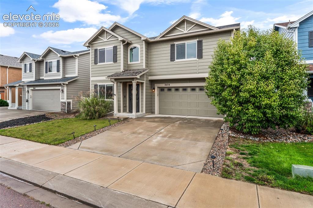Image 4 of 42: Two-story residential exterior with light-colored siding, a covered entry, 