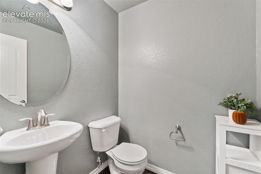 Image 9 of 42: Pedestal sink with brushed nickel faucet, oval frameless mirror, and overhe