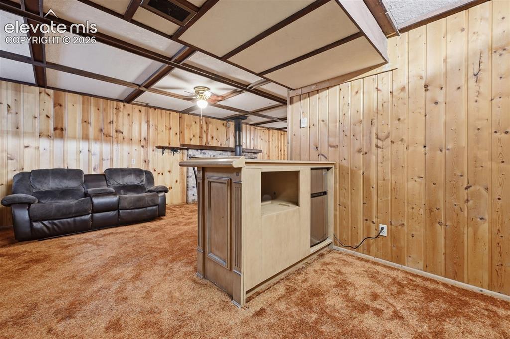 Image 22 of 30: Basement Family Room with Bar and Built-ins