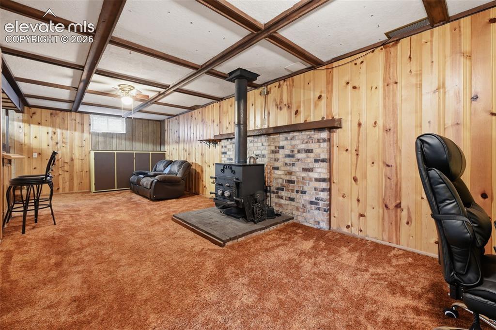 Image 24 of 30: Basement Family Room with Woodburning Stove