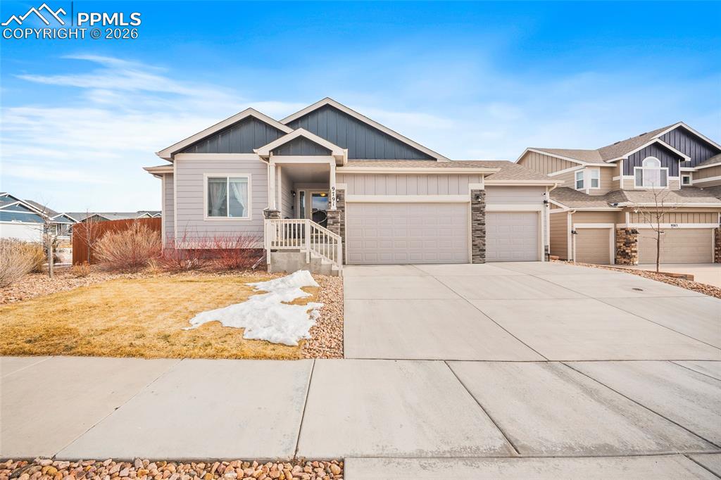 Caption: Craftsman-style house with concrete driveway, stone siding, and a garage