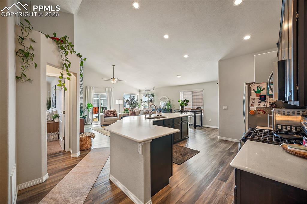 Image 10 of 43: Kitchen with open floor plan, an island with sink, gas stove, dark wood-typ