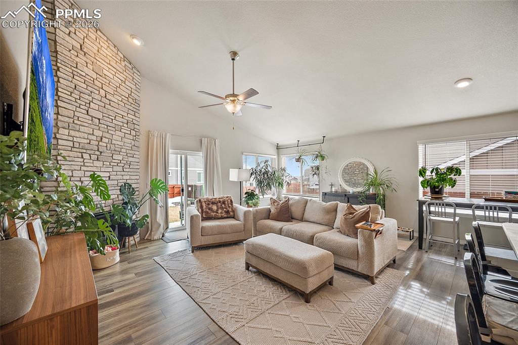 Image 15 of 43: Living room with wood finished floors, ceiling fan, plenty of natural light