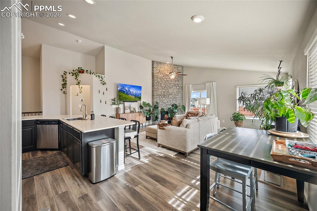 Image 23 of 43: Kitchen featuring vaulted ceiling, dishwasher, wood finished floors, light 