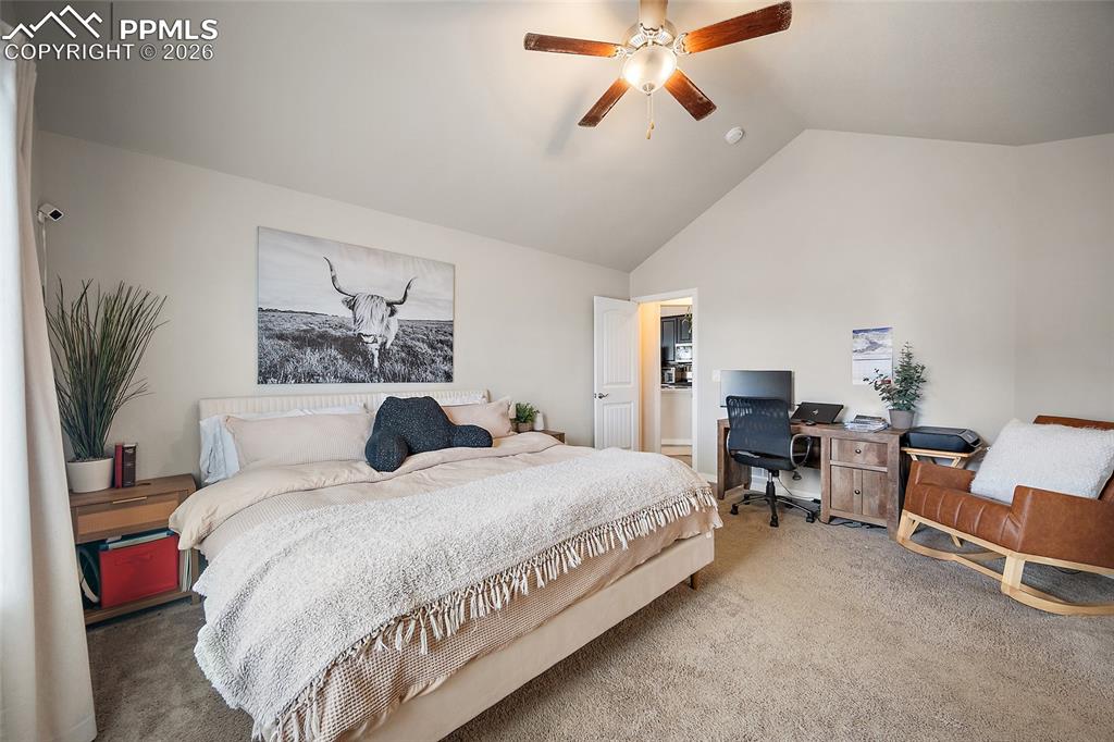 Image 26 of 43: Bedroom featuring carpet flooring, a desk, a ceiling fan, and high vaulted 