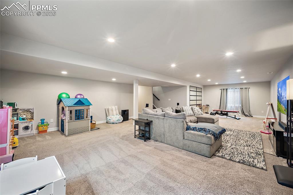 Image 34 of 43: Living room with light carpet and recessed lighting