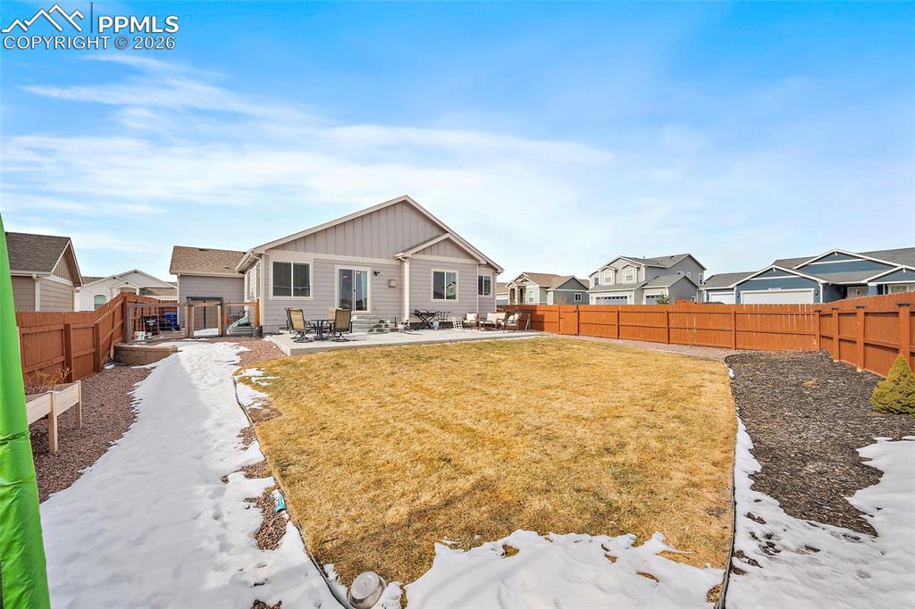 Image 41 of 43: Snow covered property featuring a patio area, a fenced backyard, board and 