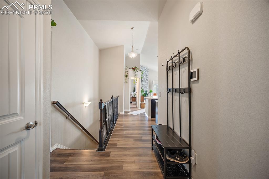Image 5 of 43: Hall with an upstairs landing, dark wood-type flooring, and lofted ceiling
