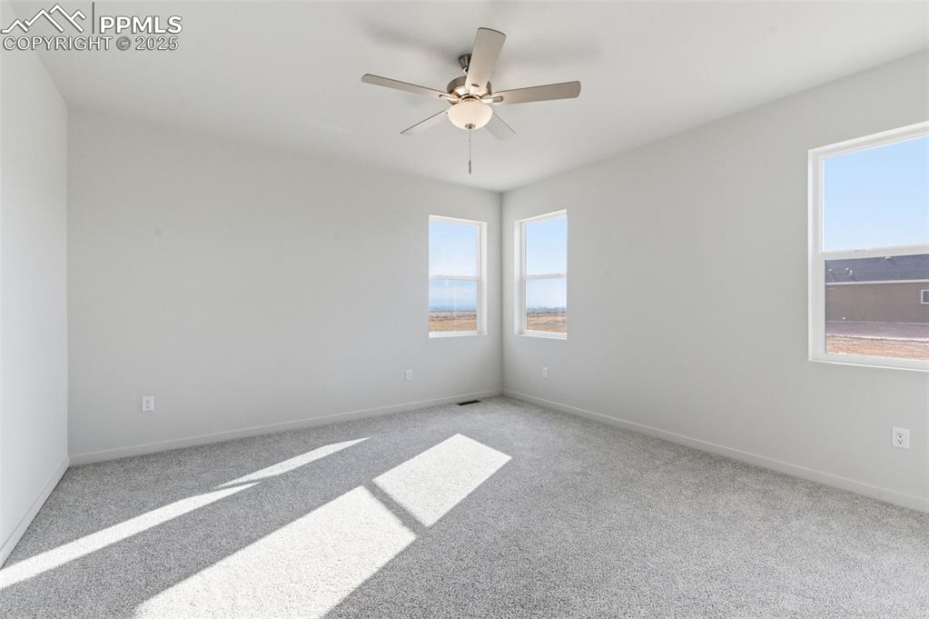 Image 17 of 26: Carpeted spare room with ceiling fan and baseboards