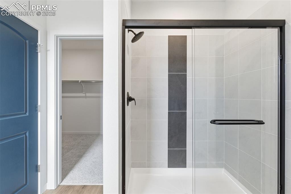 Image 23 of 26: Full bath with a walk in closet and a stall shower
