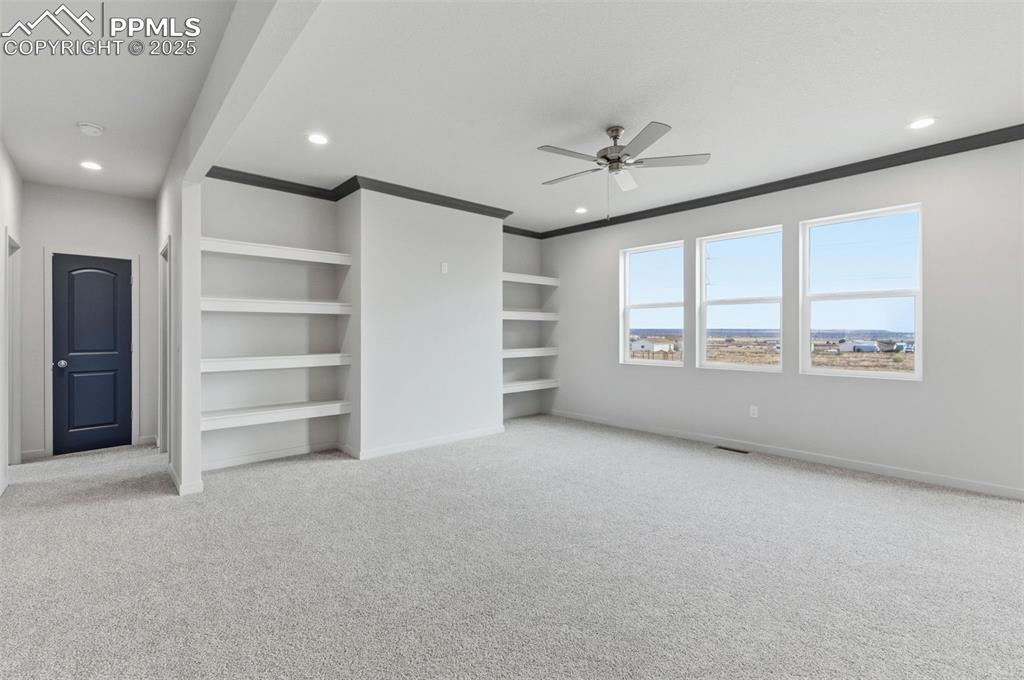 Image 5 of 26: Unfurnished bedroom with light colored carpet, a ceiling fan, ornamental mo