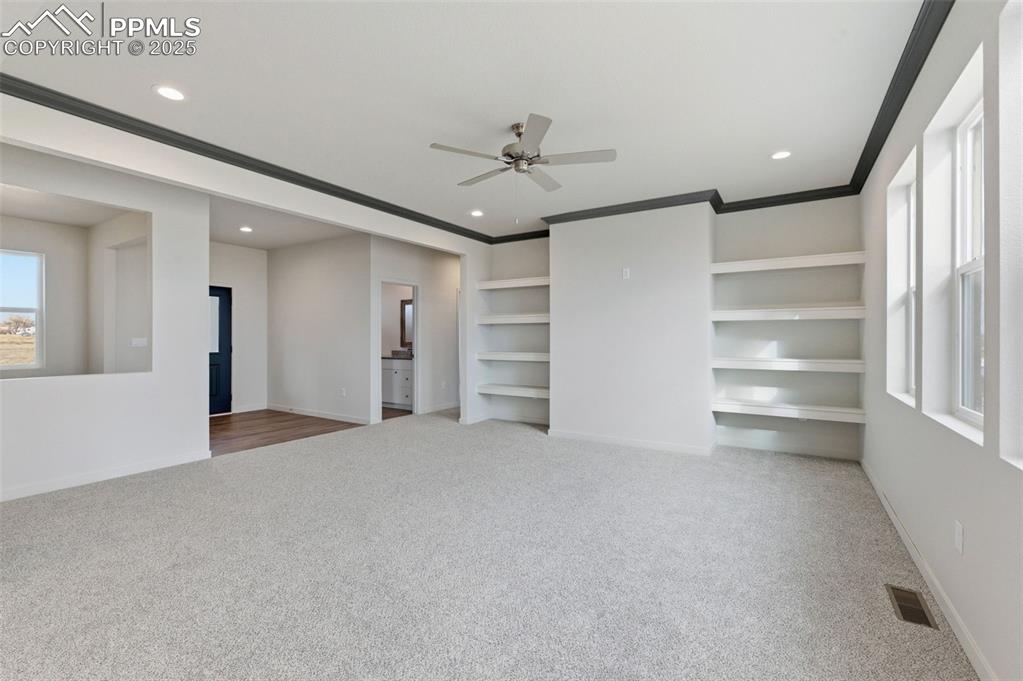 Image 6 of 26: Unfurnished living room featuring built in features, ceiling fan, light col