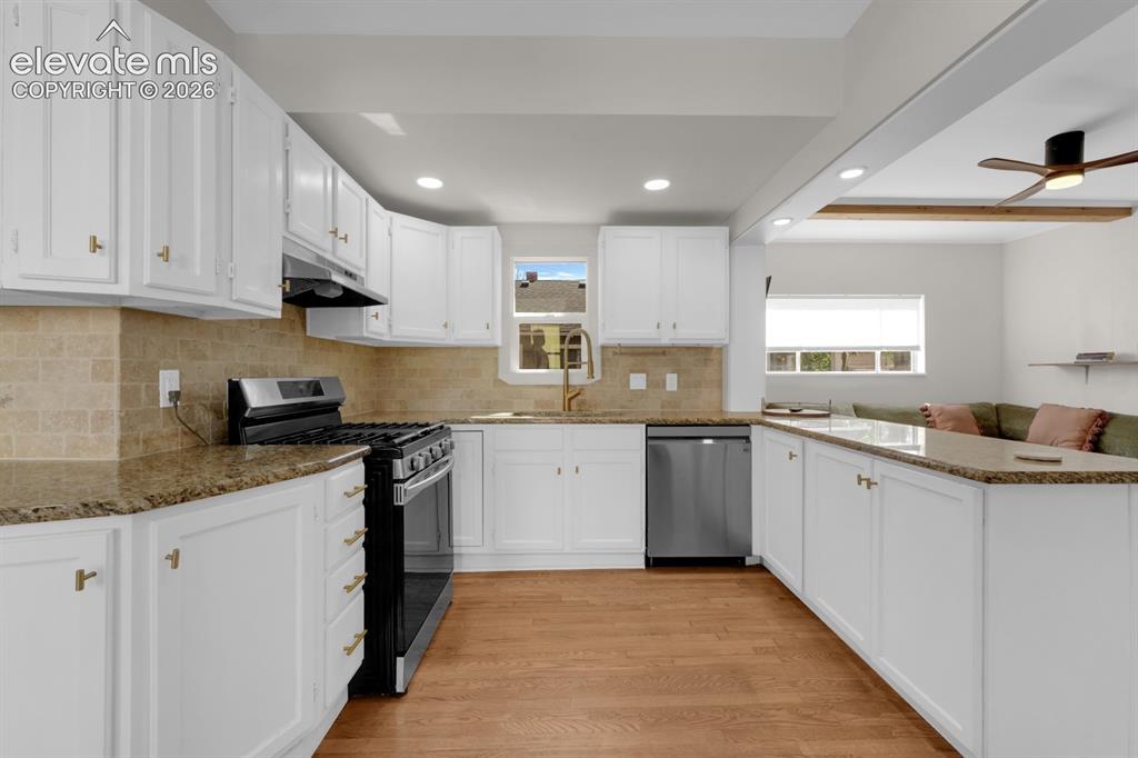 Image 10 of 32: Kitchen featuring white cabinetry, stone countertops, stainless steel appli
