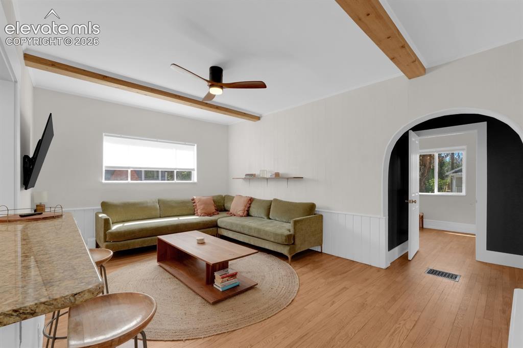 Image 12 of 32: Living room with natural light & beamed ceiling