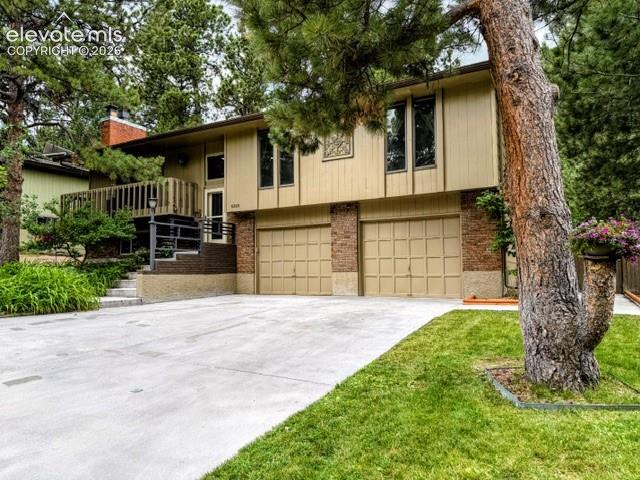 Image 1 of 46: Split-level exterior featuring tan siding and brick accents