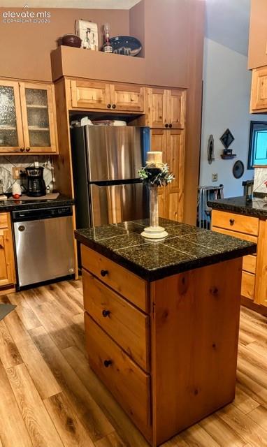 Image 13 of 46: Kitchen featuring a central island with a tiled countertop, stainless steel