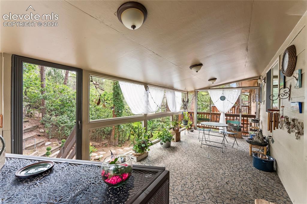 Image 17 of 46: Enclosed patio featuring a patterned floor, multiple windows, and a wood ce