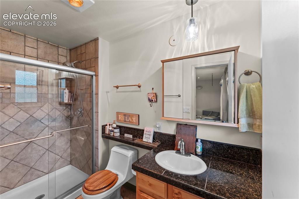 Image 23 of 46: Bathroom featuring a glass-enclosed shower with tile surround, a built-in s