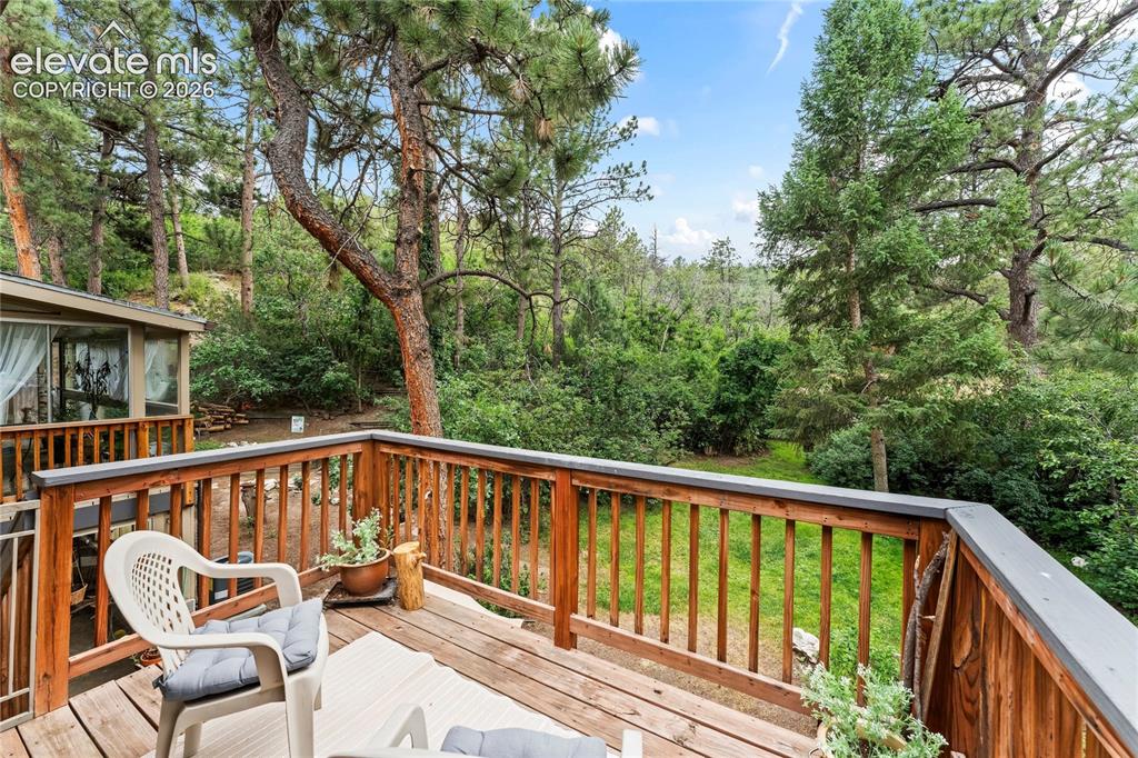 Image 24 of 46: Wood-finish deck featuring a slatted railing and verdant surroundings
