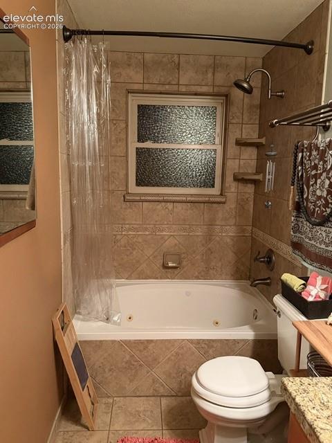 Image 26 of 46: Bathroom featuring a jetted tub, ceramic tile surround, and a frosted windo