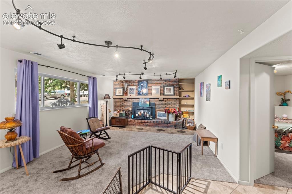 Image 34 of 46: Garden level windows, wood burning fireplace, upgraded lighting