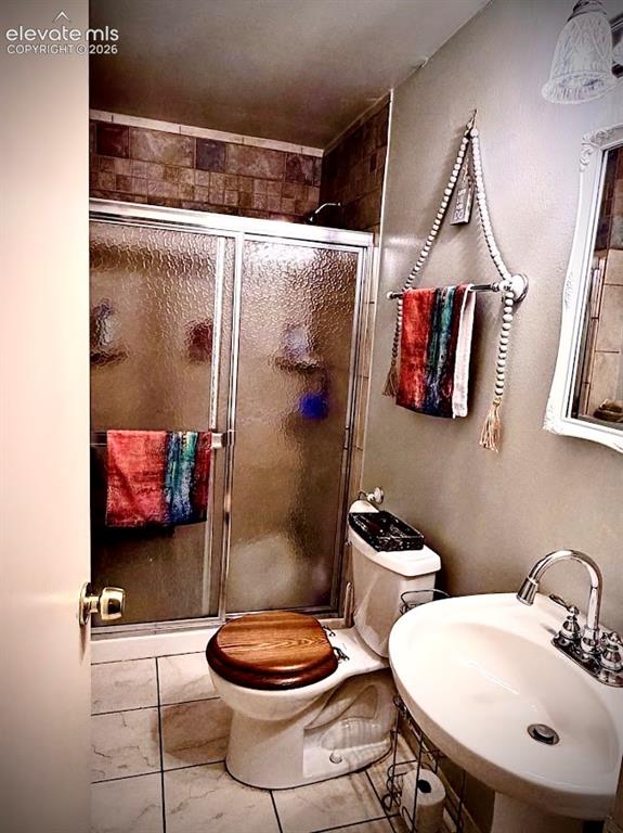 Image 35 of 46: Lower level bathroom featuring a tiled walk-in shower with sliding glass do