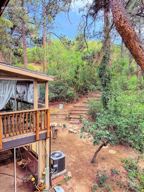 Image 38 of 46: Tiered backyard with natural landscaping and mature trees