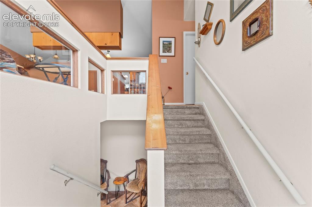 Image 4 of 46: Carpeted staircase with light wood-finish railing