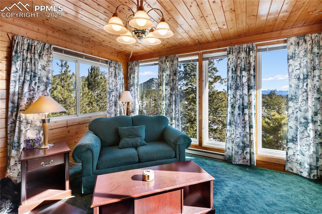 Image 12 of 33: Sunroom with plenty of natural light and a chandelier