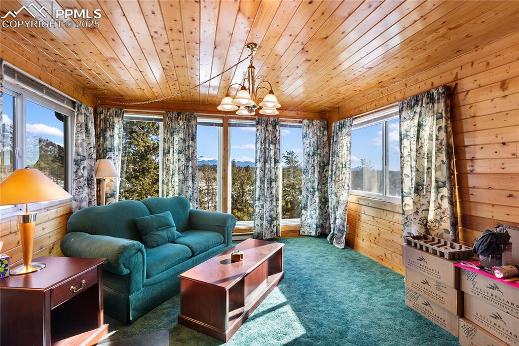Image 13 of 33: Sunroom with plenty of natural light and a chandelier