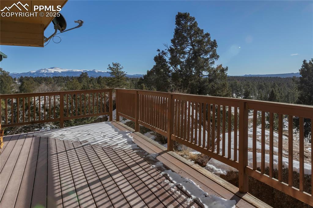 Image 2 of 33: Wooden terrace with a Pikes Peak view and a view of trees