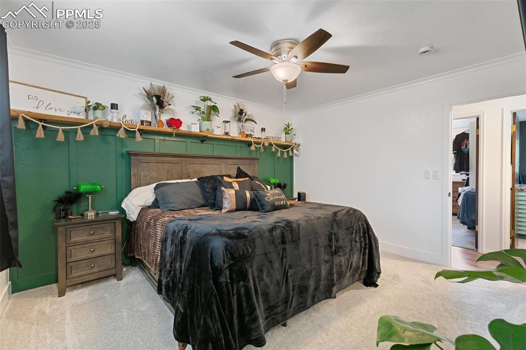 Image 17 of 45: Carpeted bedroom with crown molding and a ceiling fan