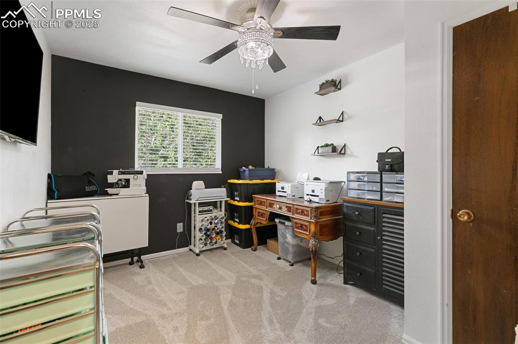 Image 21 of 45: Office area with light carpet and ceiling fan