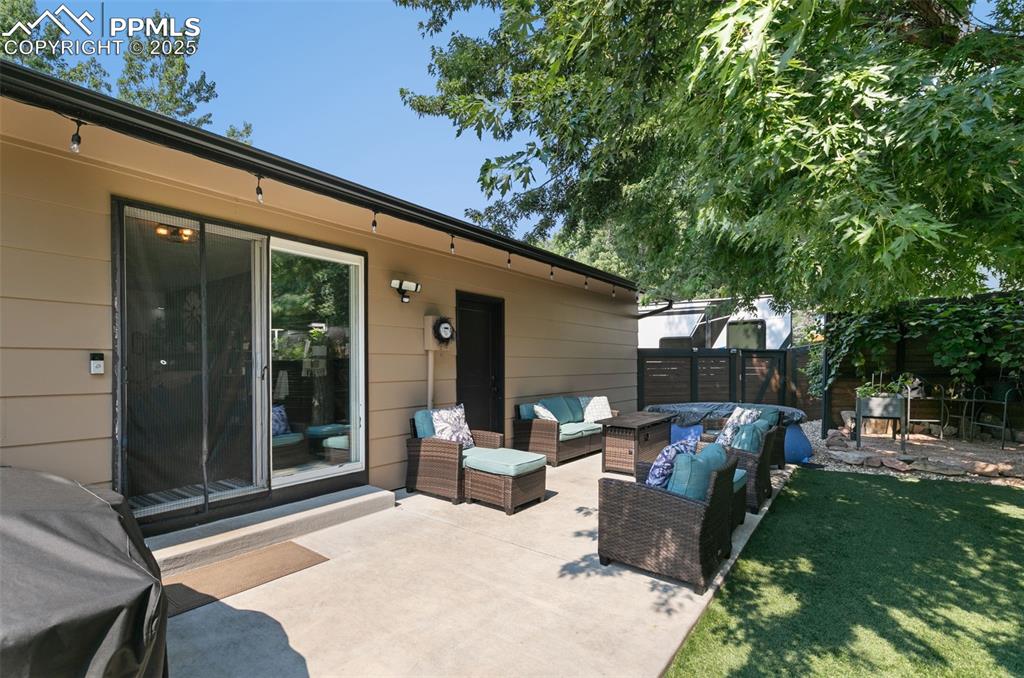 Image 24 of 45: Fenced backyard featuring a patio and an outdoor hangout area